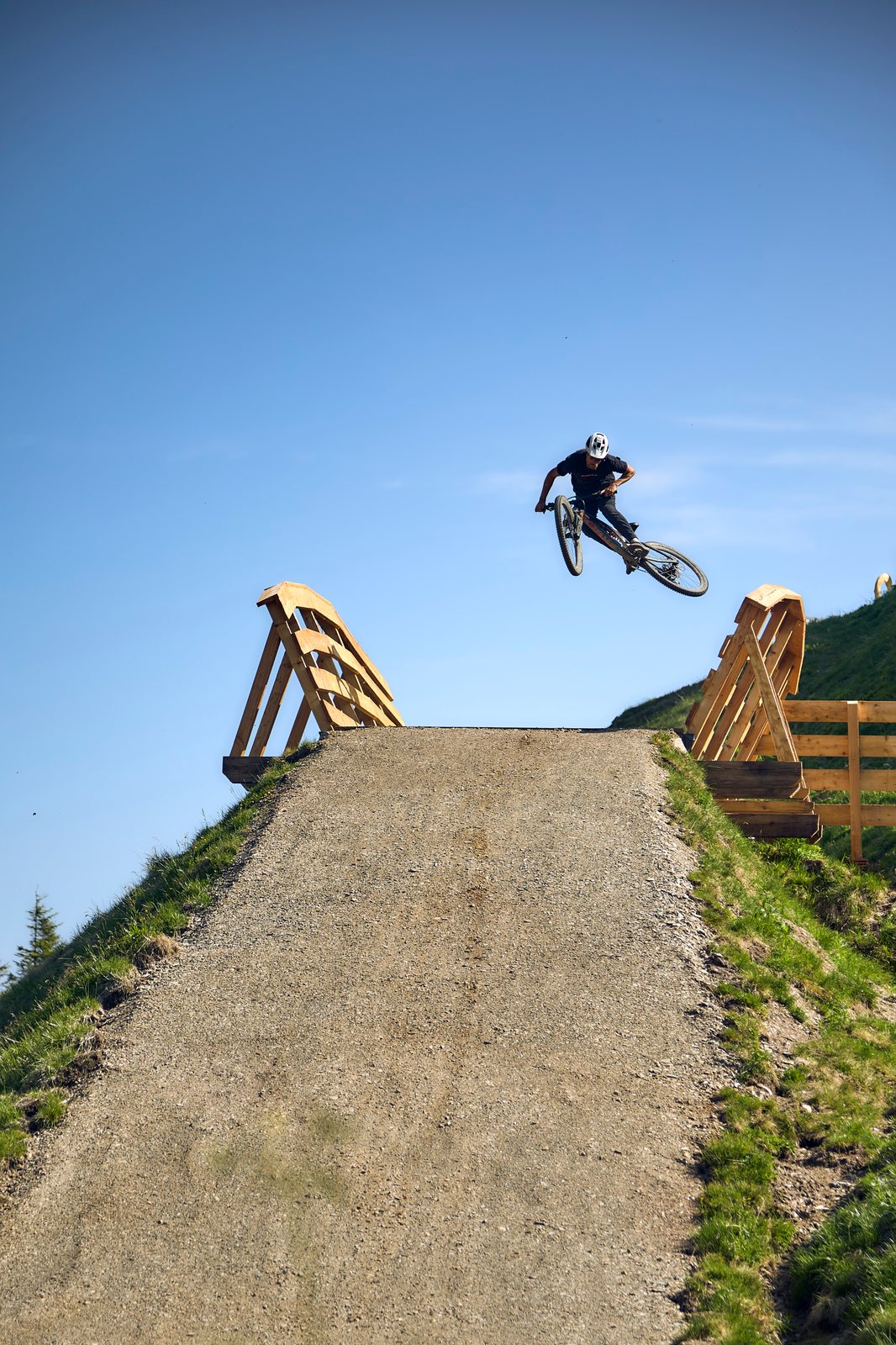 Alpiner Flowtrail mit Holzbrücke und weiten Anlegerkurven am Zwölferkogel.